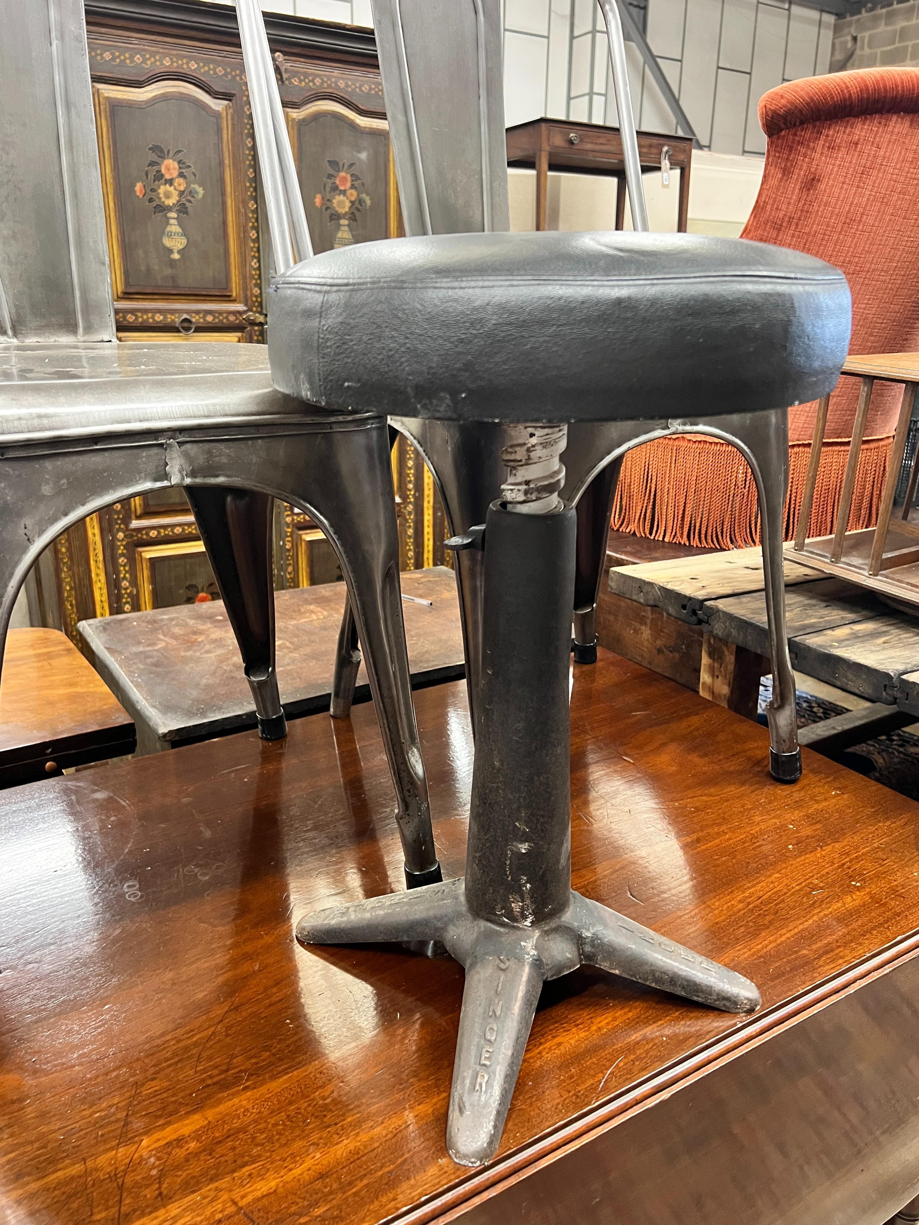 A pair of industrial style polished steel chairs and an adjustable Singer stool